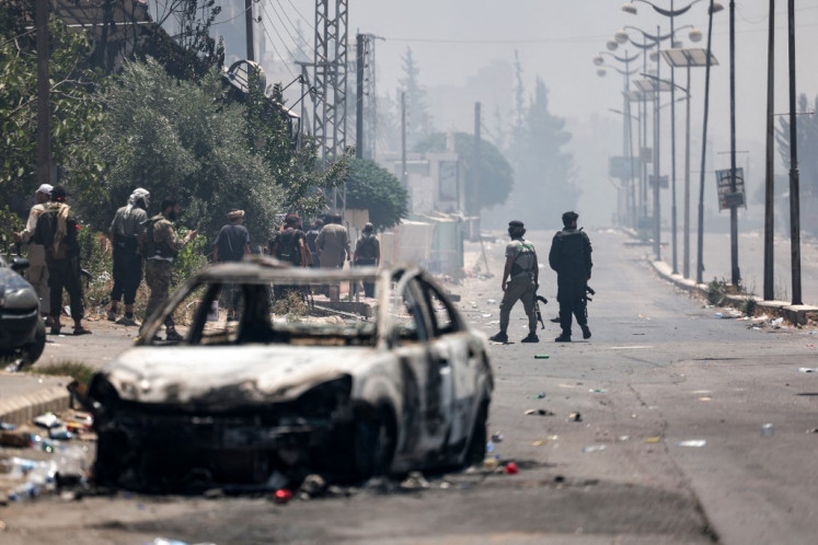 Beduin and tribal gunmen keep a position during clashes with Druze fighters in Syria's southern city of Sweida, despite an announcement by the Syrian interim president of an “immediate ceasefire“ on July 19, 2025. At least 940 people have been killed in Syria's Sweida province, a war monitor said on July 19 in an updated toll for nearly a week of violence in the heartland of the Druze minority.